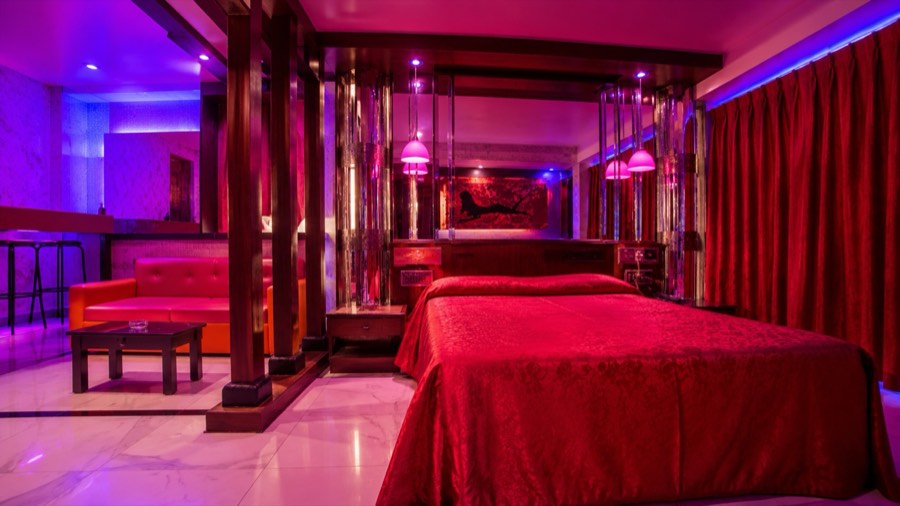 Habitación con cama matrimonial, iluminación regulable y estar privado en Hotel Avectua Pilar