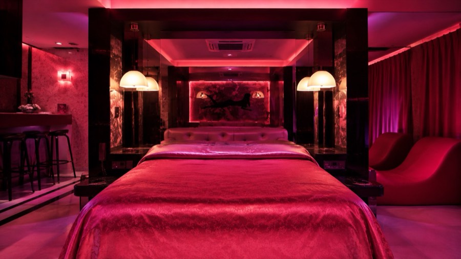 Habitación amplia con sillón y espejos en el albergue transitorio Hotel Avectua
